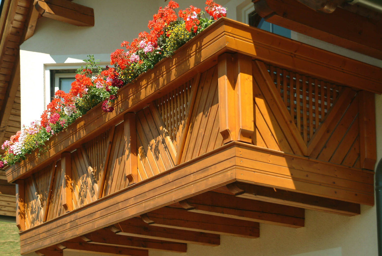 Rote Balkonblumen mit Holz Classic Langoarone Balkongeländer
